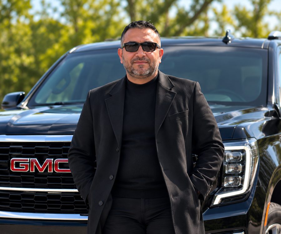 Muataz A. — Professional Chauffeur Muataz A., professional chauffeur with Milwaukee to O'Hare, standing in front of a black GMC SUV