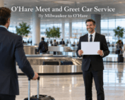 O'Hare meet and greet car service, with a chauffeur in a dark suit holding a name sign for an arriving traveler at an airport baggage claim